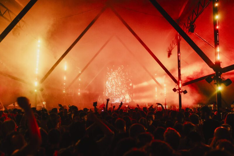 een podium met vuurwerk en een meute mensen ervoor
